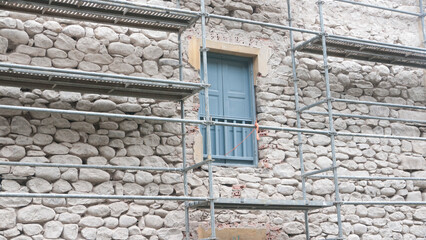 Fototapeta na wymiar Andamios en fachada de casa rural de piedra
