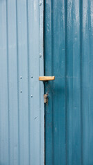Puerta de metal corrugado en dos tonos de azul