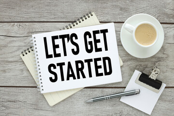 Text Let us get started text on an open notebook near a cup of coffee. light wooden background