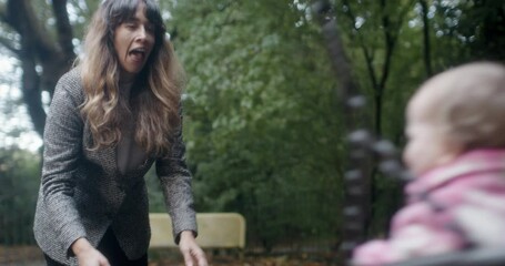 MS Mothers playing with daughter (2-3) on swing