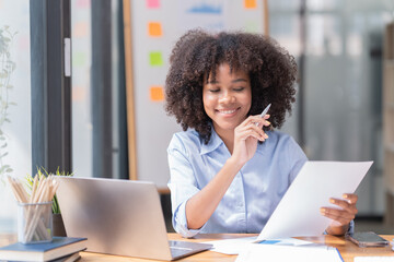 Female Entrepreneur. Cheerful African American Businesswoman Working On document and Laptop In Modern Office. Empty Space