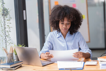 Female Entrepreneur. Cheerful African American Businesswoman Working On document and Laptop In Modern Office. Empty Space