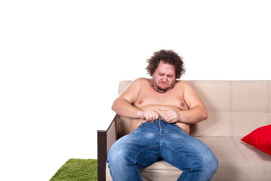Funny fat man is sitting on the couch. Diet and healthy lifestyle.	