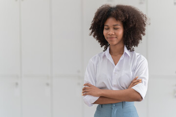 Young businesswoman smiling, holding a smartphone and leaning on a counter, enjoying a coffee break in a modern office environment, connecting with technology and staying productive