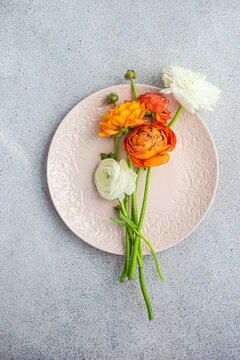 Table setting with seasonal flowers on concrete background