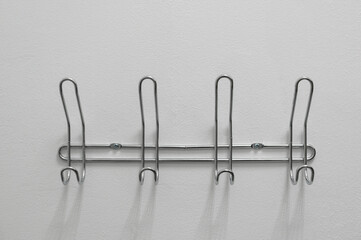 Metal hangers on the white wall close up