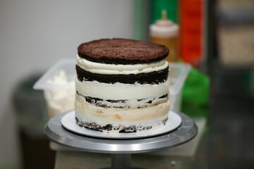 there is a cake on a small silver cake stand, which sits on a glass