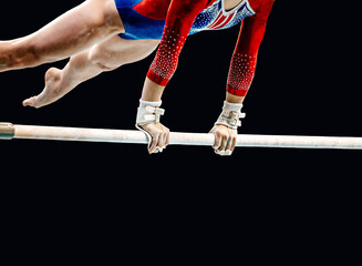 close-up female gymnast exercise on uneven bars in artistic gymnastics, black background, sports...