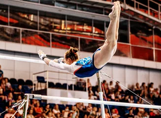 Abwaschbare Fototapete Antwerpen flight element from low bar to high bar female gymnast exercise on uneven bars in artistic gymnastics