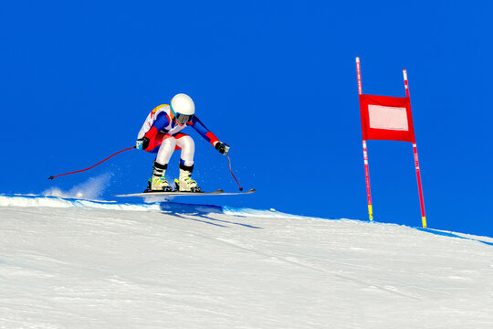 female racer on alpine skiing track, snowy slope on blue sky background, winter sports games