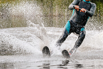 man athlete waterskiing behind motorboat on lake, extreme summer water sports