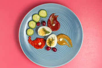 top view boiled eggs with ketchup cucumbers and mustard inside plate on the pink background food meal egg plant raw color phoot