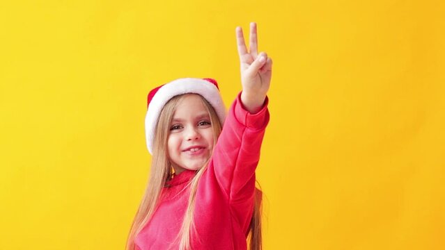 Portrait of a child girl in a Santa hat, color background