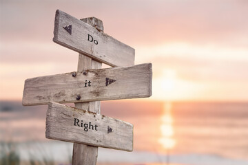 do it right text quote written on wooden signpost at the beach during sunset.