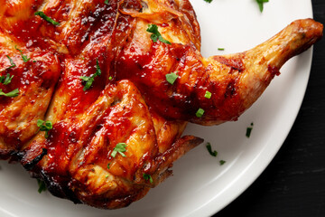 Homemade Spatchcocked Grilled Piri-Piri Chicken with Parsley on a Plate, top view. Overhead, from above, flat lay. Close-up.