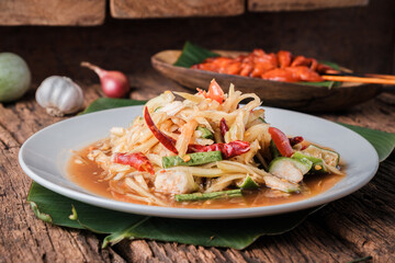 Close up, (som Tam) Thai Papaya Salad, with side dishes that can be eaten together perfectly.