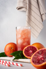 Juice or cocktail of red Sicilian oranges with ice cubes in a glass