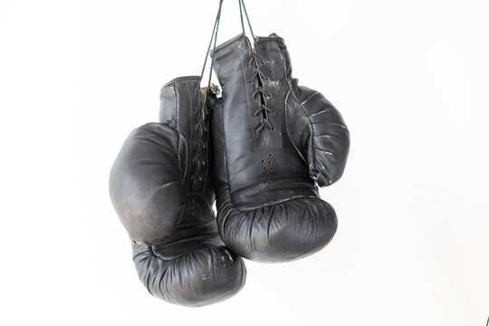 hanging old worn leather boxing gloves isolated on white background