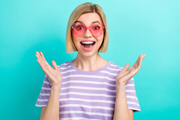 Portrait of impressed optimistic woman with short haircut dressed stylish t-shirt staring open mouth isolated on teal color background