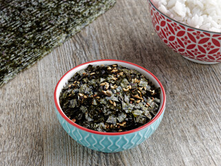 Vegan furikake seasoning with torn nori seaweed. Japanese cuisine condiment in a bowl.