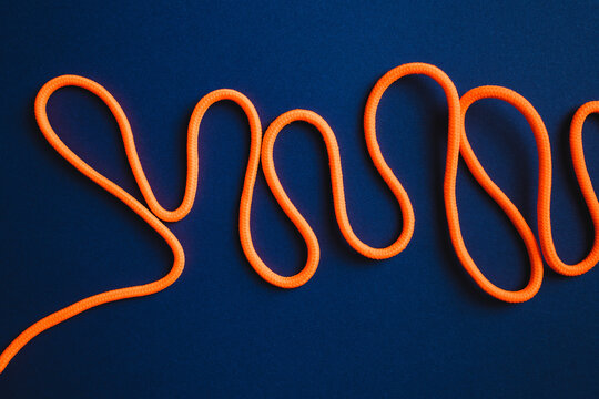 Orange vivid shoelaces on blue backdrop