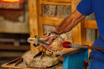 glass master while working in Murano furnace glass factory Venice Italy