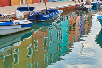 Fototapeta na wymiar Burano island canal reflection, colorful houses and boats