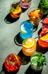 Cocktails set on rusty green bar counter, top view. Mixology concept. Assortment of colorful strong and low alcohol drinks for summer cocktail party. Dark background, hard light