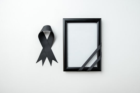 top view picture frame with black bow on white desk death funeral