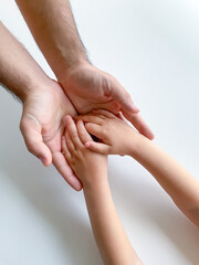 Adult and child hold their hands together. Fathers Day Child gives hand to adult