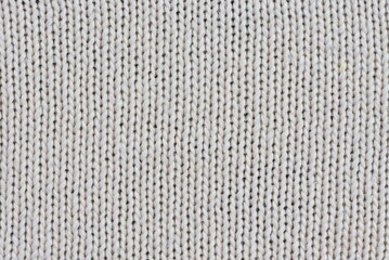 Close-up of cream-colored knit fabric for backgrounds and designs.