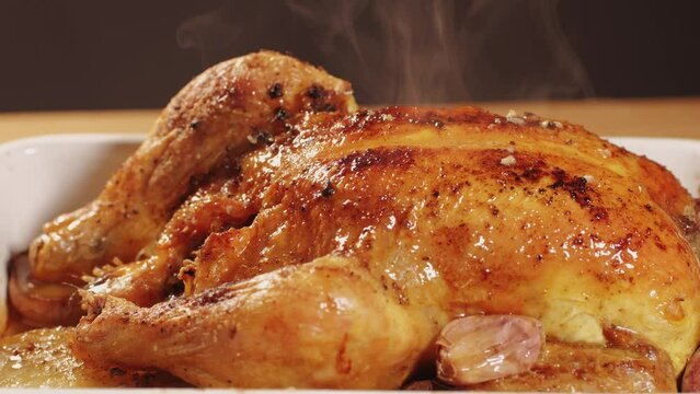 Full roasted grilled chicken meat in a frying pan with potatoes, cooked food, delicious crust, sause pouring. 