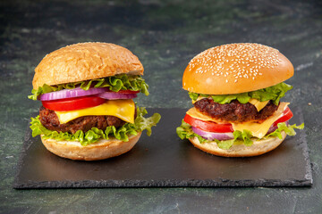 Delicious sandwiches on black board on dark mix color background
