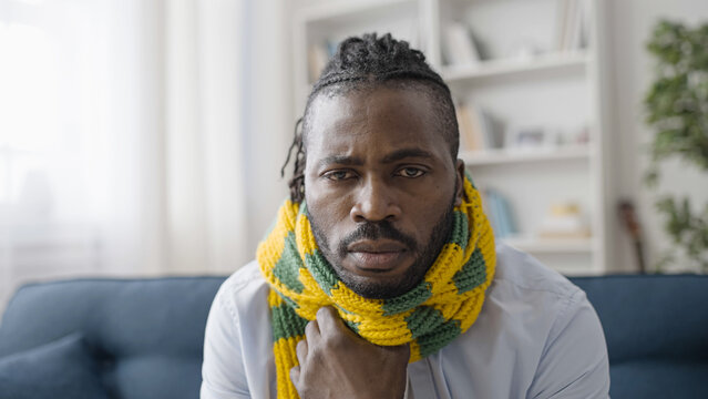 Portrait of upset sick man in warm scarf suffering from flue or cold, coronavirus