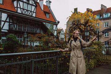 Outdoor smiling lifestyle portrait of pretty young woman having fun in the city in Europe. Gdansk, Poland. High quality photo. High quality photo