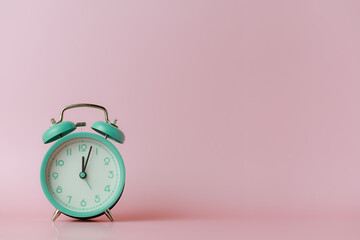 A bell alarm clock on pink background for the concept of time management.