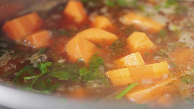 Hungarian goulash soup cooking close-up in pot, chef cook traditional polish or zech soup in restaurant. 