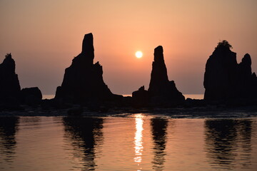早朝の海岸に立つ奇岩
