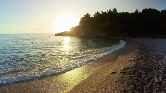SVETI STEFAN, MONTENEGRO - SEPTEMBER 18, 2021: Scenic Adriatic sea beach in Sveti Stefan and the sunset, Montenegro - 4K, Ultra-wide