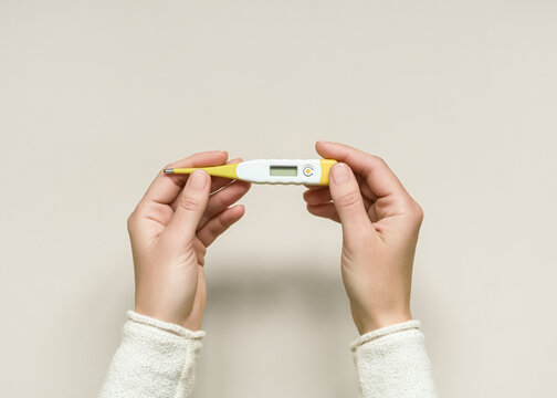 woman holding an electronic thermometer