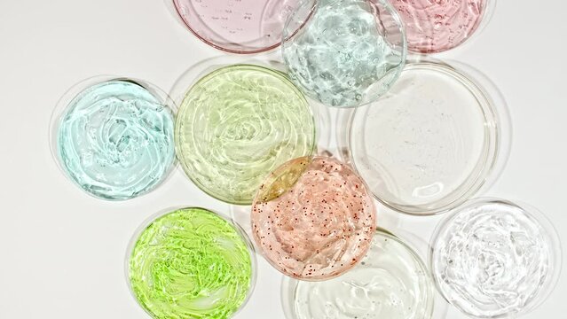Rotation of Petri Dishes with Cosmetic Gel Fluid with Bubbles on a White Background. Transparent Gel Fluid, Serum, Cream. Chemical laboratory research. Natural Organic cosmetics, medicine. 4k