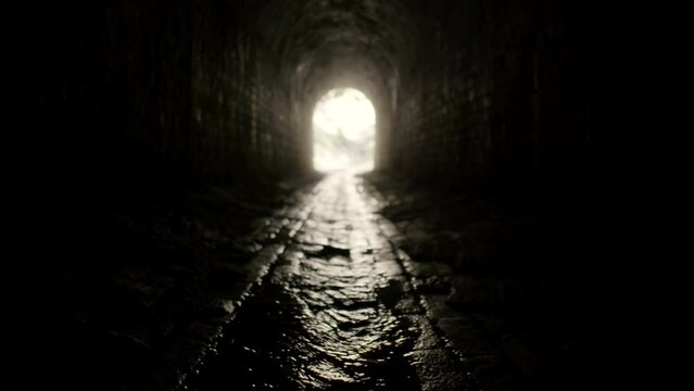 A water flowing on the ground of a dark tunnel