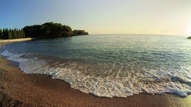 SVETI STEFAN, MONTENEGRO - SEPTEMBER 18, 2021: Scenic Milocer beach and Adriatic sea in Sveti Stefan and the sunset, Montenegro - 4K, Ultra-wide, Pan