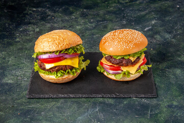 Homemade delicious sandwiches on black board on dark mix color background