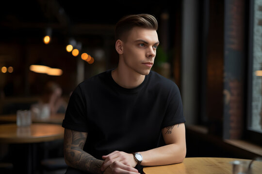 Young man wearing bella canvas black t shirt and jeans, at a cozy restaurant on summers day. Design tshirt template, print presentation mockup. Ai generated.