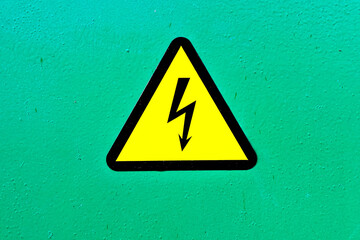Sign black lightning in a yellow triangle on a green background dangerous electricity, high voltage