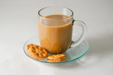 cup of cappuccino on a saucer and some peanut butter cookies isolated on a white background