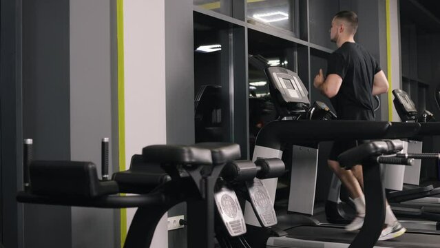 Fitness goals, Strength training, Gym treadmill. The gym member is running on a treadmill for his workout.
