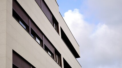 facade of a building with windows and shutters against the sky