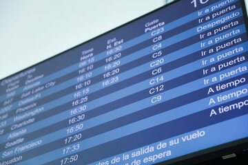 airport monitor displaying the status and destinations of business flights represents the...